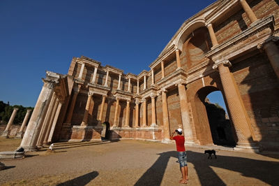 Man photographing of historical building against sky