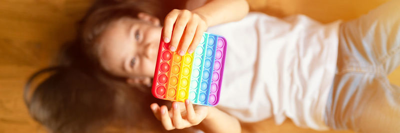 High angle portrait of girl holding multi colored candies