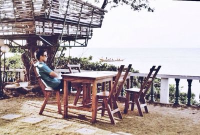 Woman sitting on chair at beach