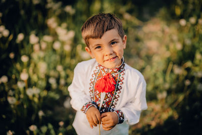 Portrait of boy standing against plants