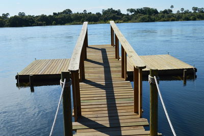 Wooden pier over lake against sky