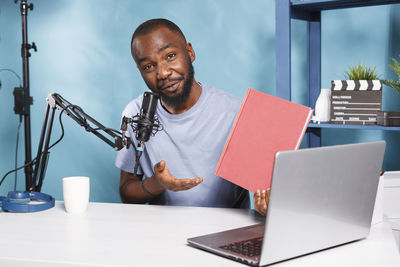 Portrait of young man using digital tablet on table