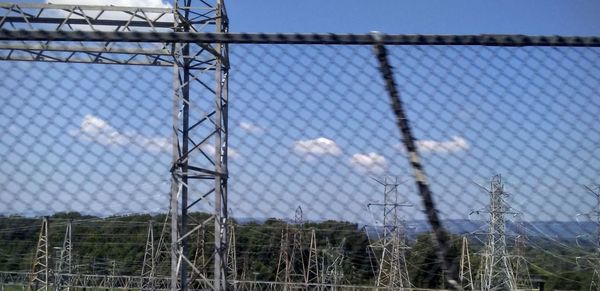 Low angle view of chainlink fence against sky