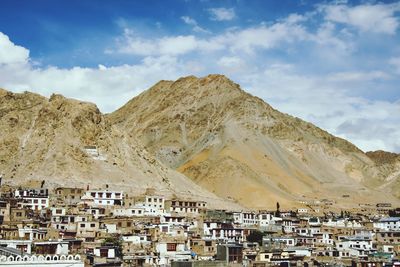 View of cityscape against cloudy sky