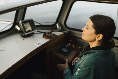 Young woman driving motorboat