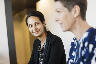 Businesswoman looking at colleague during discussion in meeting