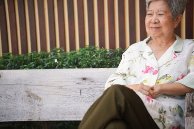 Portrait of smiling woman sitting on bench