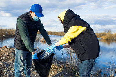 People cleaning garbage near lake