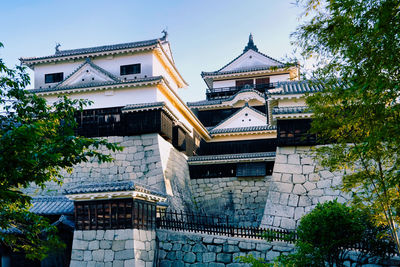 Low angle view of japanese castle building against sky