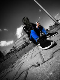 Midsection of woman sitting against sky