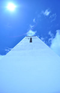 Low angle view of snow covered blue sky