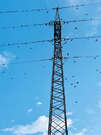 Low angle view of elettricity pylon against sky