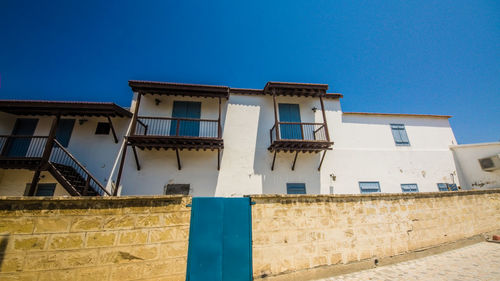 Low angle view of old building against clear blue sky