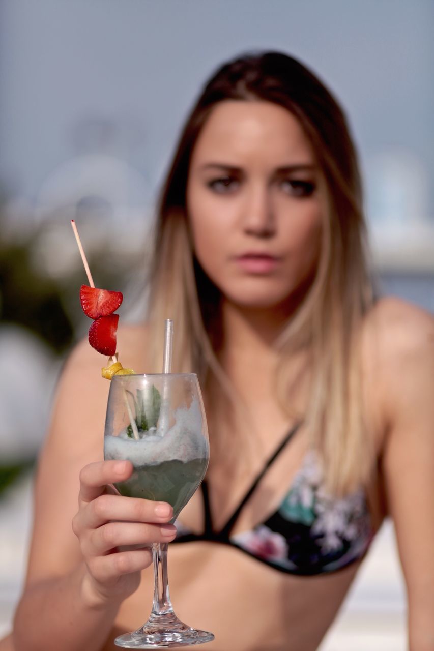 cocktail, focus on foreground, alcohol, refreshment, drink, food and drink, drinking straw, real people, leisure activity, close-up, outdoors, young adult, freshness, one person, water, nature, day, mojito, people