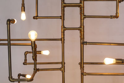 Low angle view of illuminated light bulb hanging on ceiling