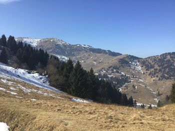 Scenic view of snowcapped mountains against clear blue sky