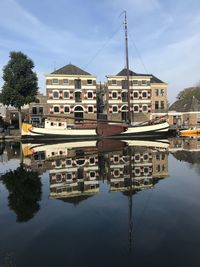 Reflection of building in lake against sky