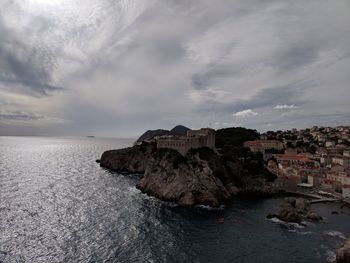 Scenic view of sea by buildings against sky