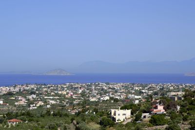 High angle view of townscape by sea against clear sky