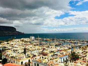 High angle view of townscape by sea against sky