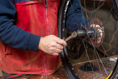 Midsection of man repairing bicycle