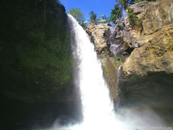 Scenic view of waterfall against sky