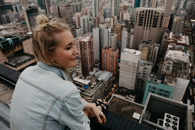 Woman sitting on building terrace in city