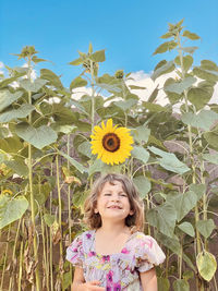 Portrait of smiling girl against blue sky