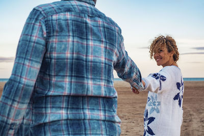 Rear view of couple standing at beach