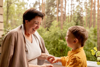 Happy grandmother and grandson enjoy time together. positive middle age woman playing with little