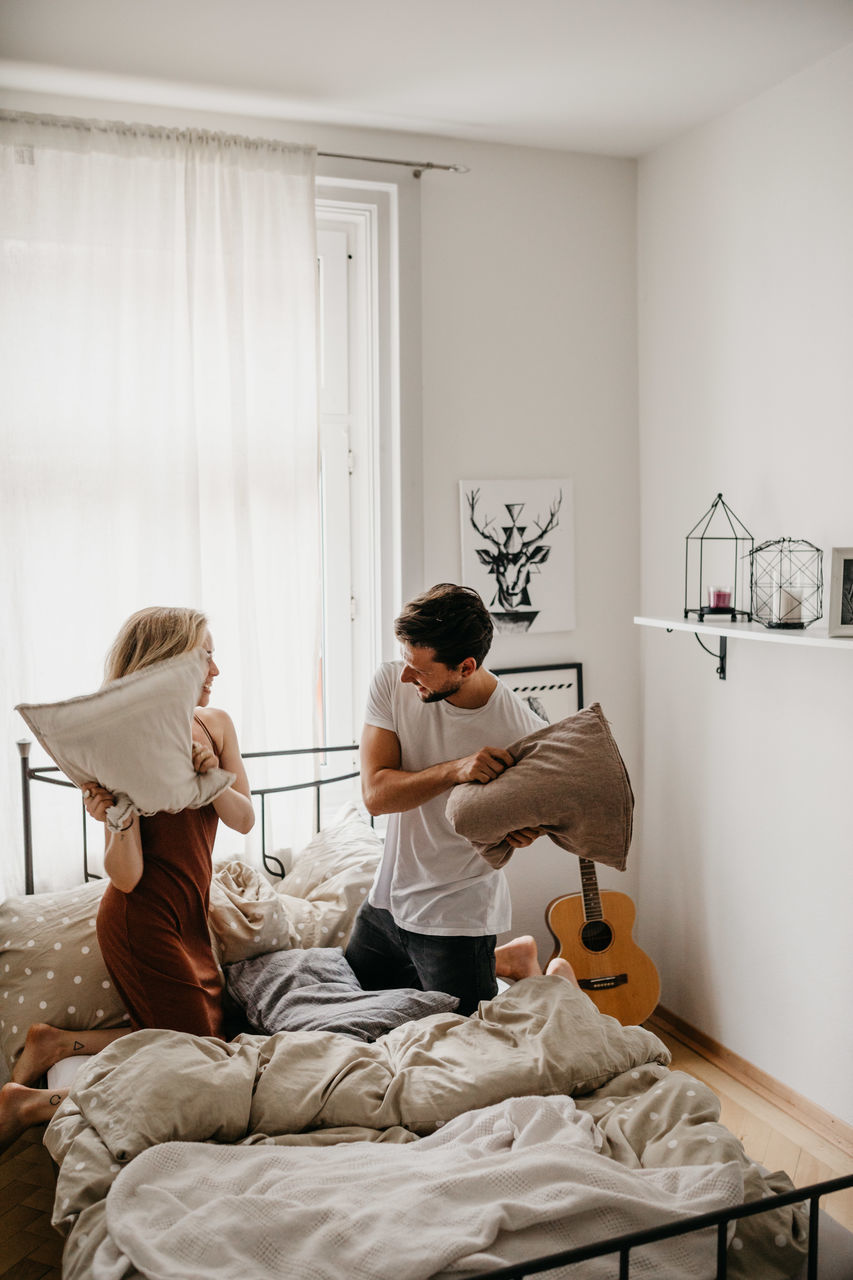 PEOPLE SITTING ON BED WITH HOME