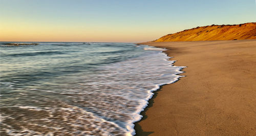 Scenic view of sea against clear sky during sunset