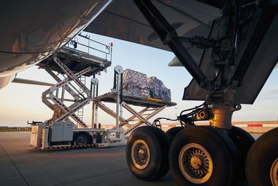 Loading of cargo containers to plane at airport. preparation freight airplane before flight.