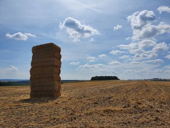 Hay bales on field against sky