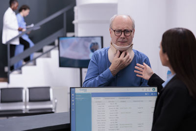 Portrait of man using mobile phone in office