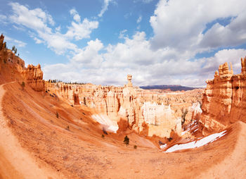 Panoramic view of rock formations against cloudy sky