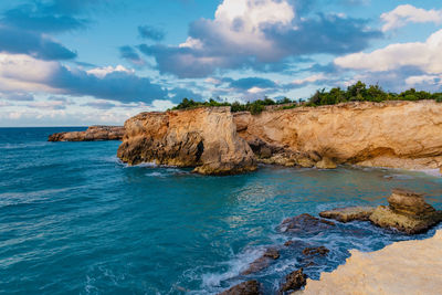 Scenic view of rocks in sea against sky