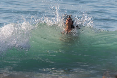 Smiling teenage girl swimming in sea