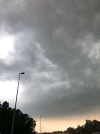 Low angle view of street light against cloudy sky