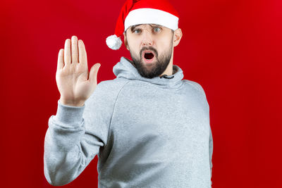 Portrait of man wearing hat against red background