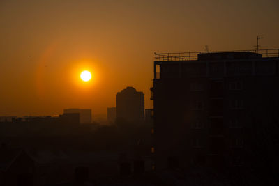 Silhouette buildings against sky during sunset