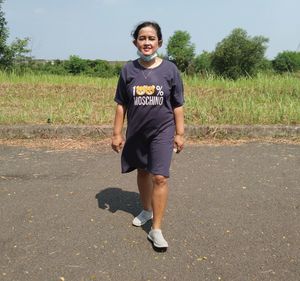 Portrait of smiling young woman standing on field