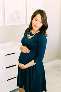 Portrait of smiling young woman standing at home