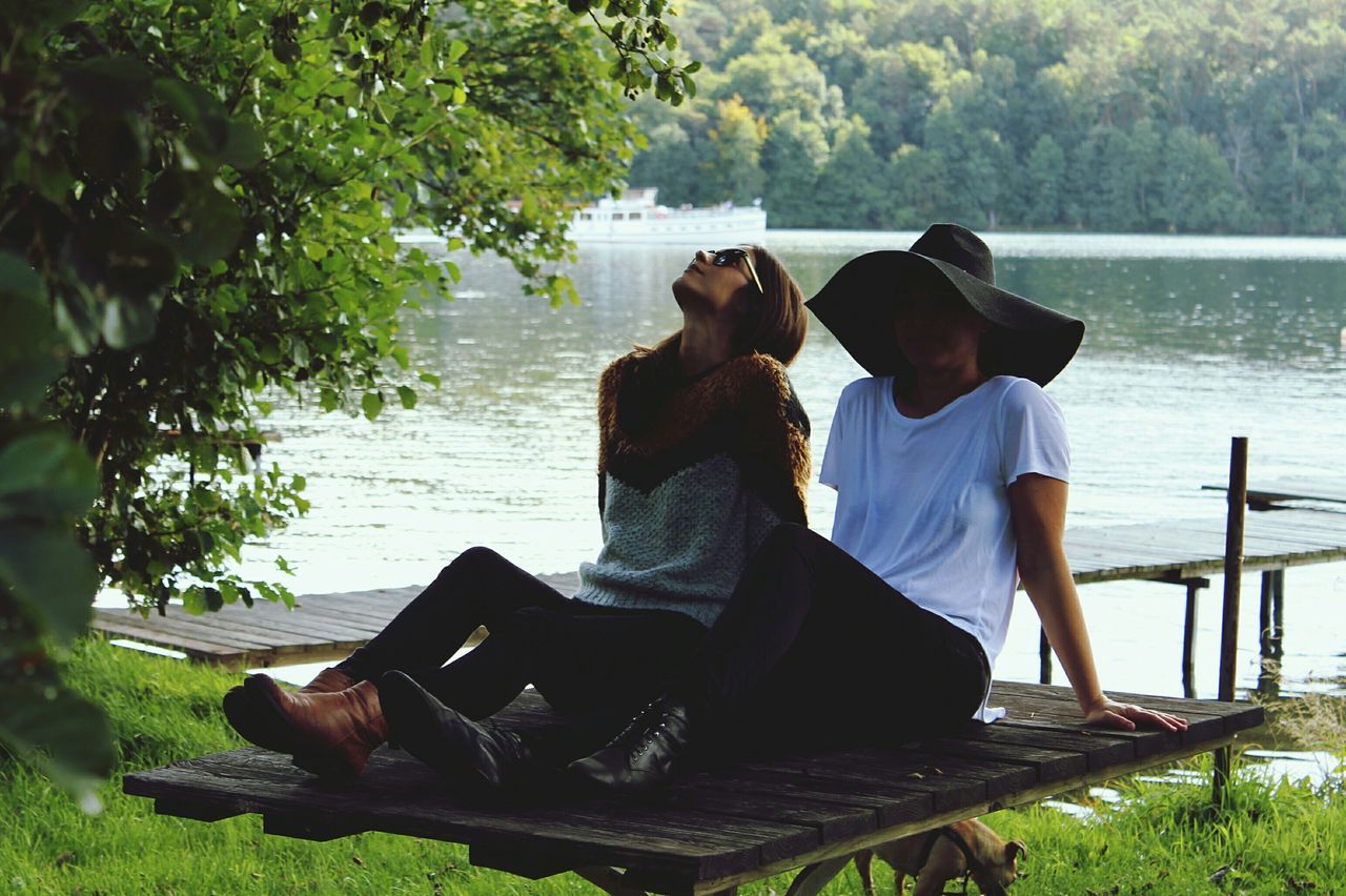 sitting, water, lifestyles, leisure activity, relaxation, men, rear view, lake, tree, nature, full length, tranquility, person, sea, nautical vessel, day, casual clothing, tranquil scene