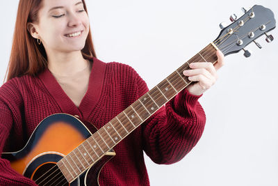 Midsection of woman playing guitar