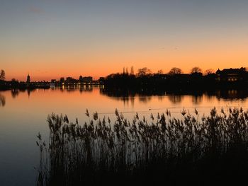 Scenic view of lake against orange sky