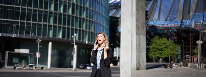 Low angle view of woman standing in city