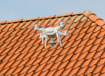 Low angle view of quadcopter flying against roof