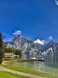 Scenic view of lake and mountains against blue sky