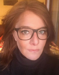 Close-up portrait of woman with eyeglasses at home